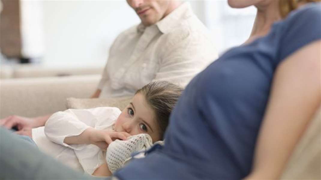 Girl-Resting-on-Sofa-Between-Parents.jpg