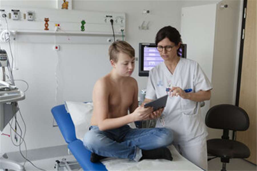 teenage-boy-and-nurse-looking-at-a-tablet-FOLF04641.jpg