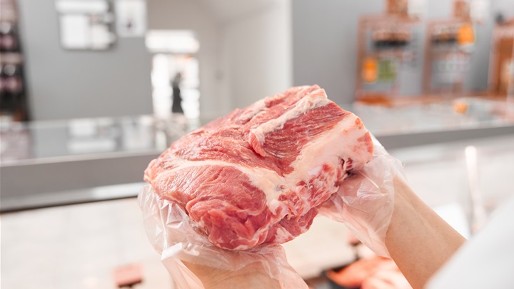 incognito-female-butcher-showing-meat-counter.jpg