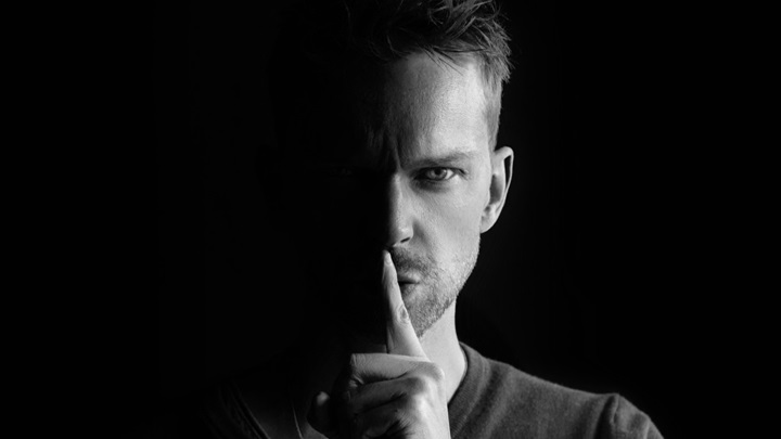 2021Men_Young_man_covering_his_mouth_with_his_finger_on_black_background_150835_22.jpg