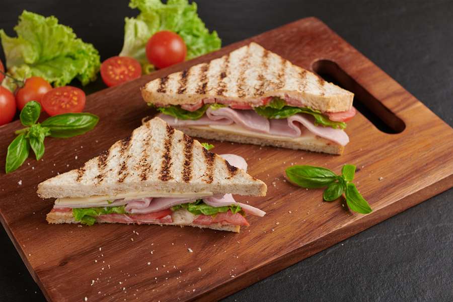 grilled-sandwich-with-ham-cheese-tomato-lettuce-served-wooden-cutting-board.jpg