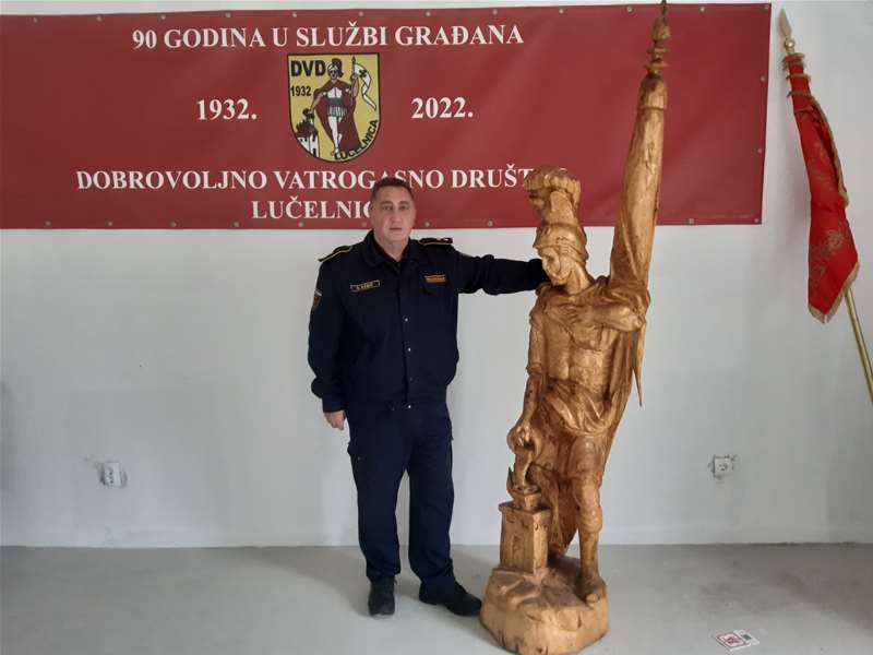 Nedjeljko Babić s drvenim kipom sv. Florijana - poklon umjetnika Željka Ilića povodom 90. godišnjice Društva.jpg