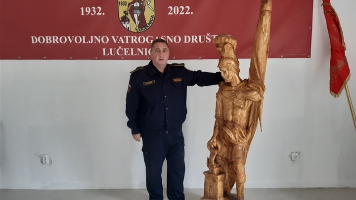 Nedjeljko Babić s drvenim kipom sv. Florijana - poklon umjetnika Željka Ilića povodom 90. godišnjice Društva.jpg